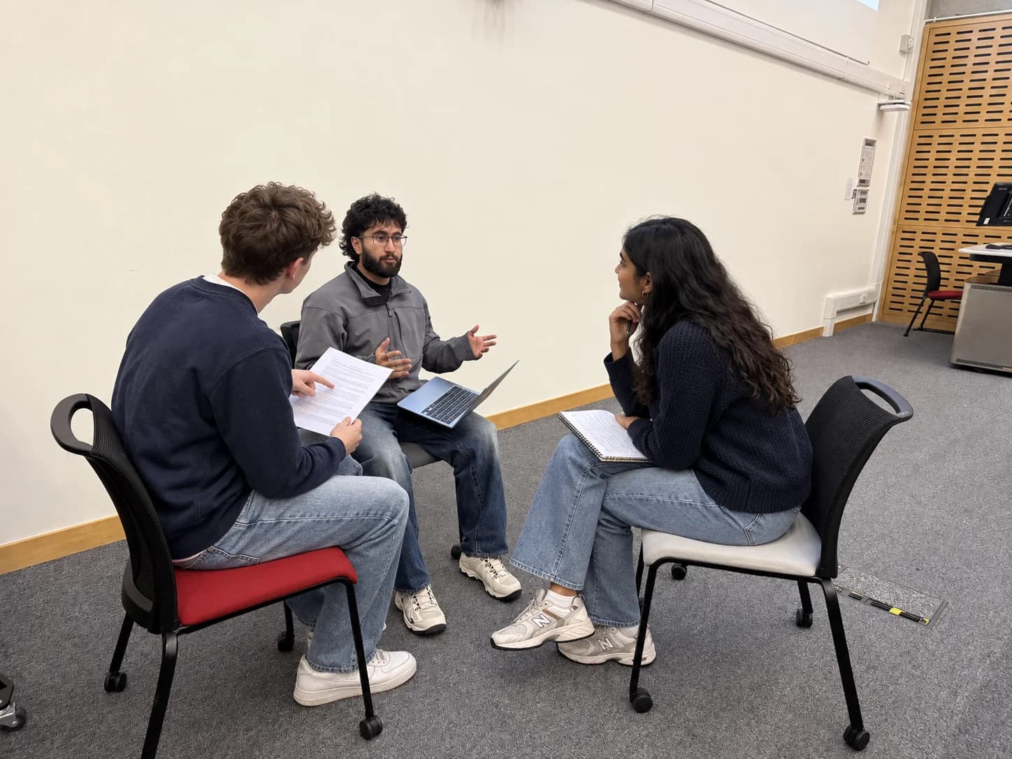 Tutor discussing an application draft with students